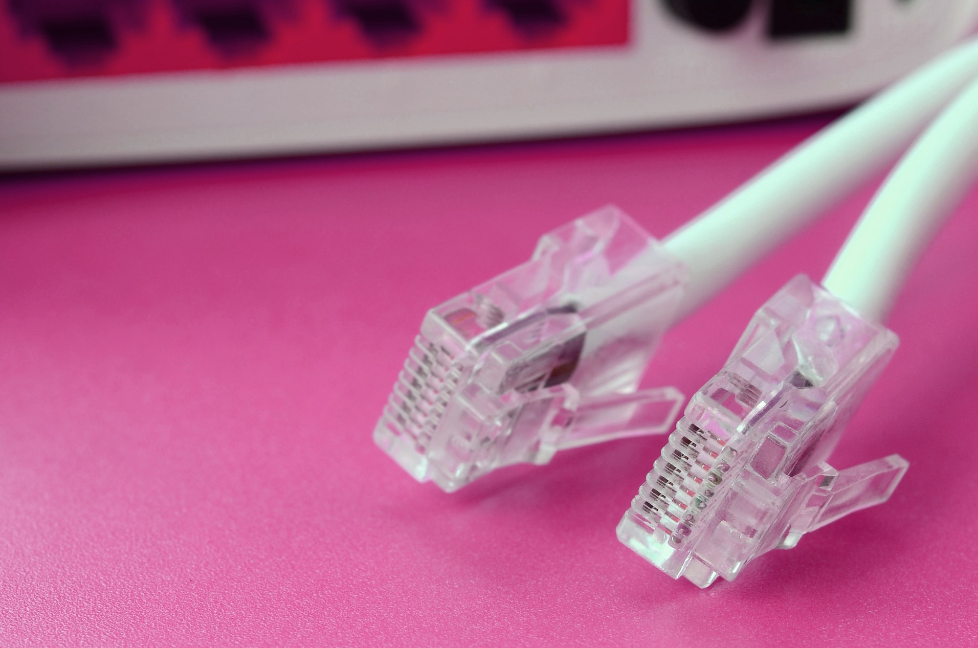 Internet router and Internet cable plugs lie on a bright pink background. Items required for Intern
